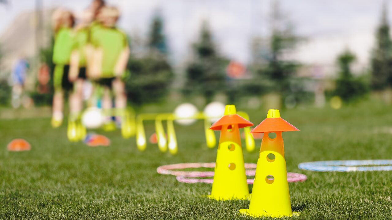 Children using sports training equipment outdoors