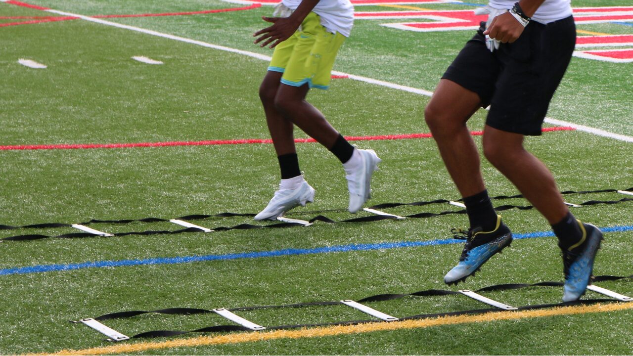 Football players performing ladder drills